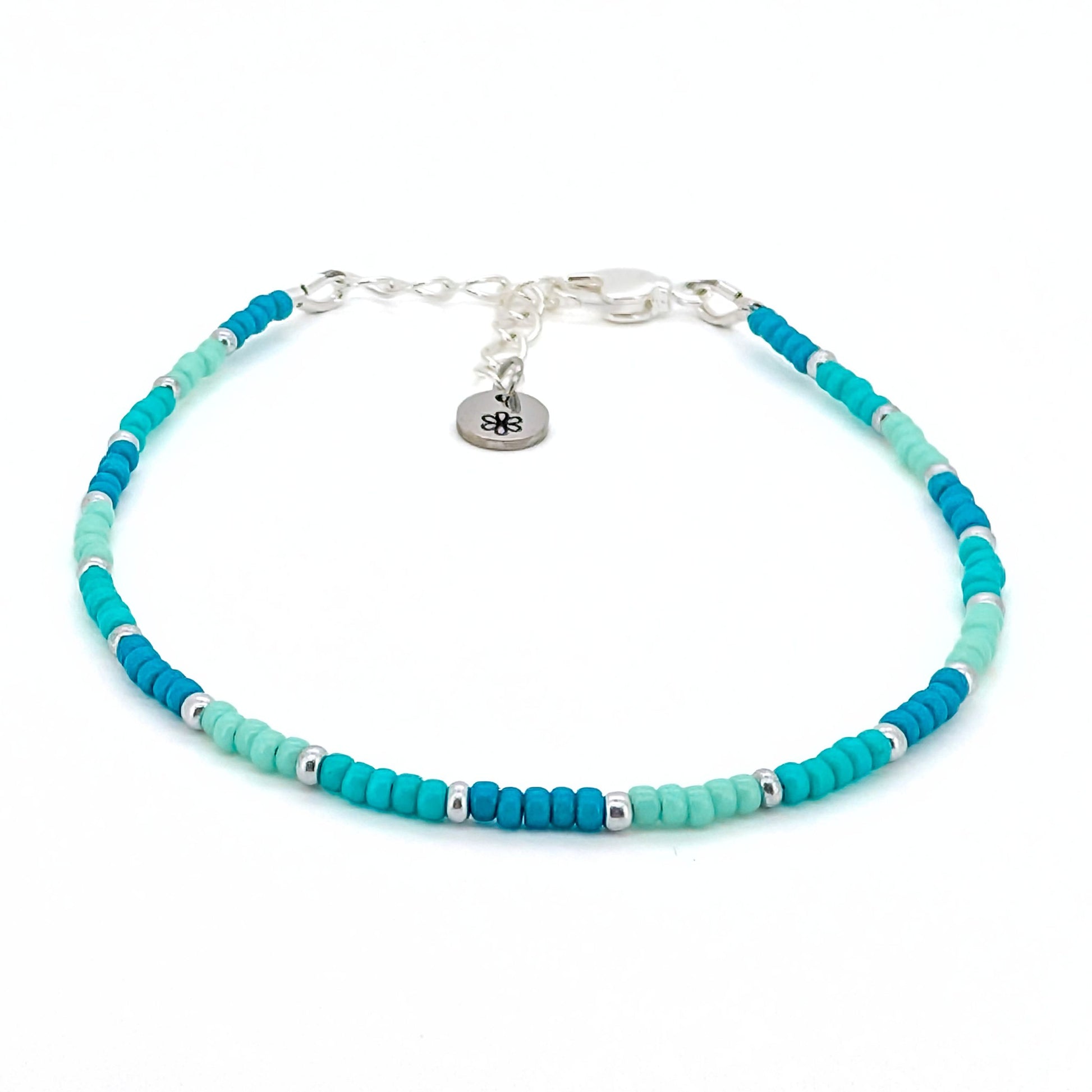 Turquoise beaded bracelet with silver accents on a white background